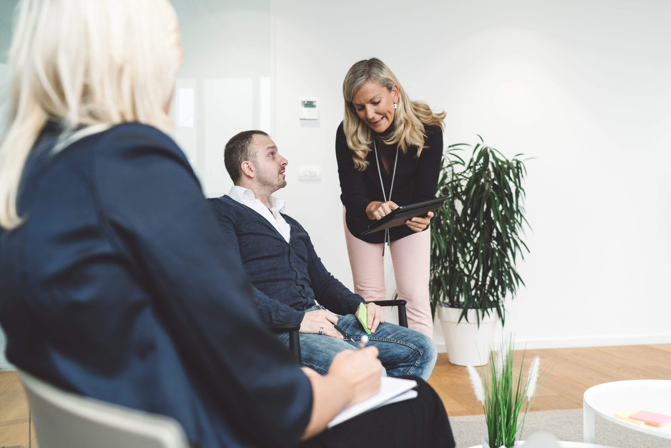Senior woman director CEO leading in-office training session, collaborative discussion between colleagues. Business people having a meeting in office lounge. People learning and working together